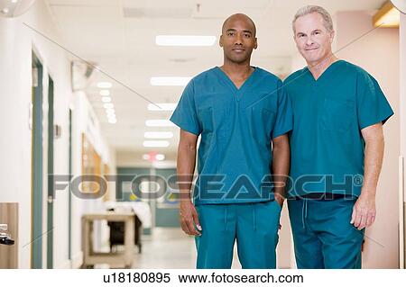 Stock Photography - Two Orderlies Standing In A Hospital Corridor. Fotosearch