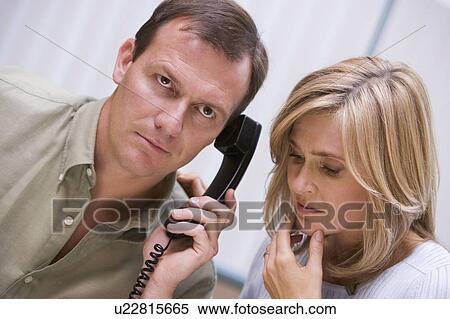 Stock Photography - Couple receiving a bad news phone call from clinic. Fotosearch