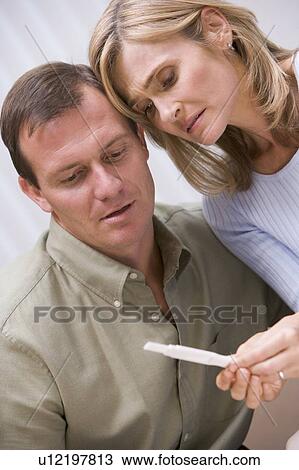 Stock Image - Couple with pregnancy test upset. Fotosearch
