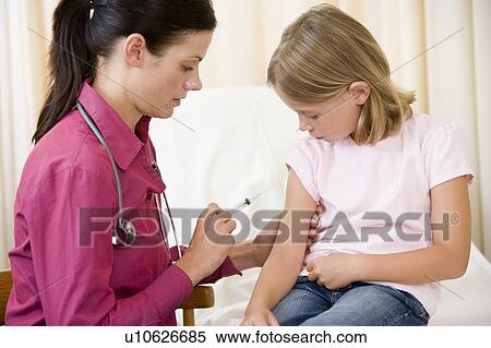 Stock Photography - Doctor giving needle to young girl in exam room. Fotosearch