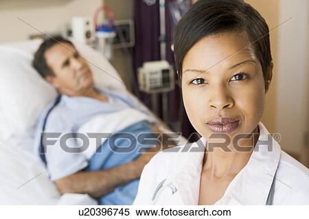 Stock Photography - Doctor Looking Serious, Standing In Hospital Room. Fotosearch