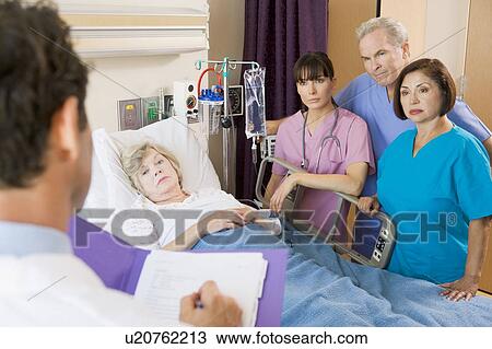 Stock Image - Doctor Making Notes On Patient. Fotosearch