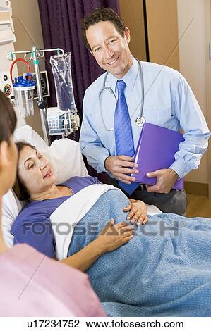 Stock Image - Doctor Standing In Patients Room. Fotosearch