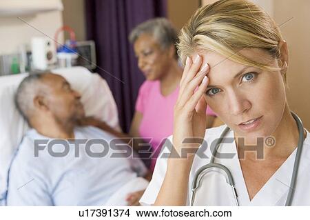 Picture - Doctor With Headache In Patients Room. Fotosearch