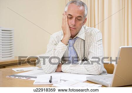 Stock Photo - Doctor with laptop in doctor's office. Fotosearch