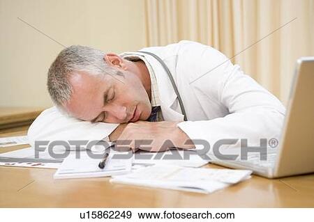 Stock Photo - Doctor with laptop sleeping in doctor's office. Fotosearch