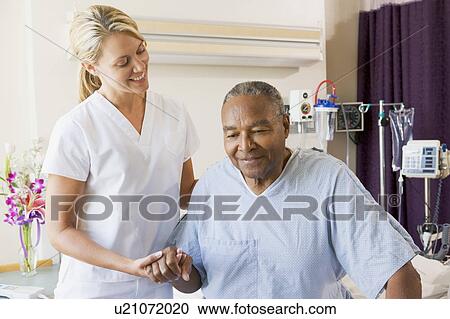 Stock Image - Nurse Helping Senior Man To Walk. Fotosearch