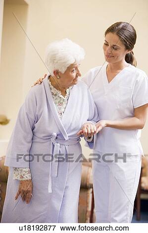 Stock Photo - Nurse Helping Senior Woman To Walk. Fotosearch