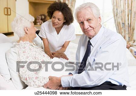 Stock Photo - Nurse Talking To Senior Couple. Fotosearch