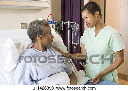 Stock Image - Nurse Talking To Senior Woman. Fotosearch