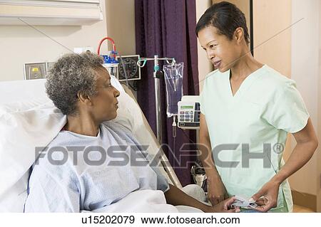 Stock Photo - Nurse Talking To Senior Woman. Fotosearch