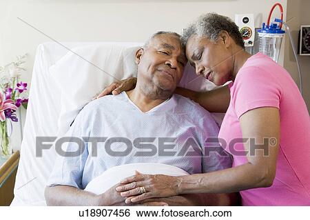 Stock Photograph - Senior Couple Embracing In Hospital. Fotosearch