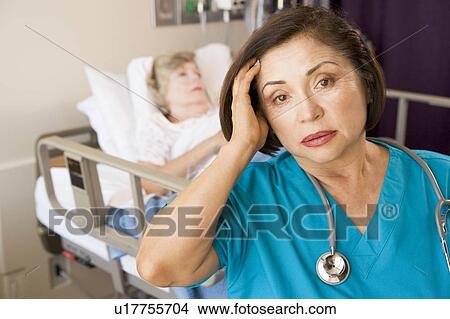Picture - Stressed Out Doctor In Patients Room. Fotosearch