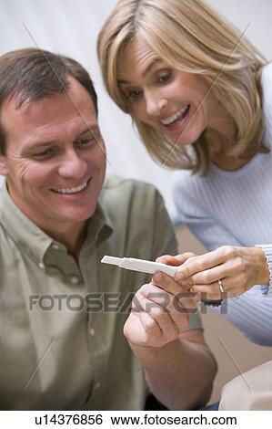 Couple with pregnancy test smiling (selective focus) View Large Photo Image Stock Photograph - Couple with pregnancy test smiling (selective focus). Fotosearch