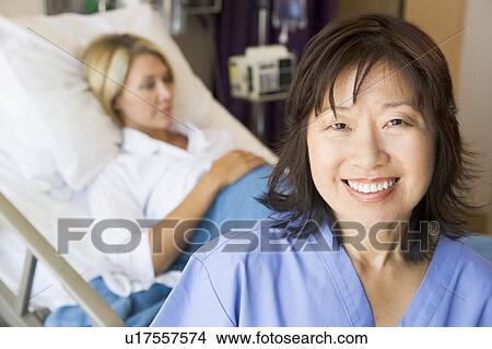 Picture - Doctor Standing In Patients Room, Smiling. Fotosearch