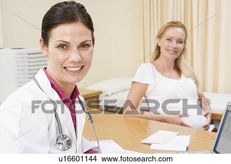 Doctor with laptop and pregnant woman in doctor's office smiling View Large Photo Image Picture - Doctor with laptop and pregnant woman in doctor's office smiling. Fotosearch