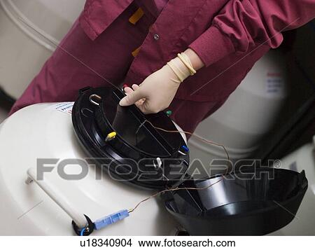 Picture - Embryologist freezing embryos for storage. Fotosearch