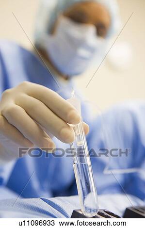 Stock Image - Nurse assisting with egg retrieval procedure. Fotosearch