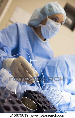 Stock Photo - Nurse assisting with egg retrieval procedure. Fotosearch