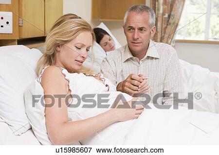 Pregnant woman in pain with husband in hospital View Large Photo Image Stock Photo - Pregnant woman in pain with husband in hospital. Fotosearch