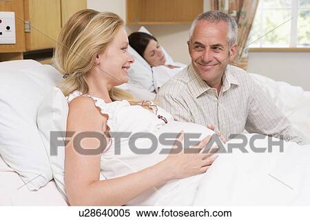 Pregnant woman with husband in hospital smiling View Large Photo Image Stock Photography - Pregnant woman with husband in hospital smiling. Fotosearch