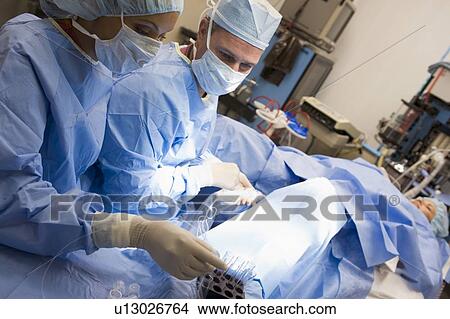 Picture - Woman in operating room undergoing egg retrieval procedure. Fotosearch