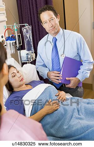 Stock Photography - Doctor Standing In Patients Room. Fotosearch