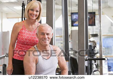 Stock Image - Man And Woman At Gym Together. Fotosearch