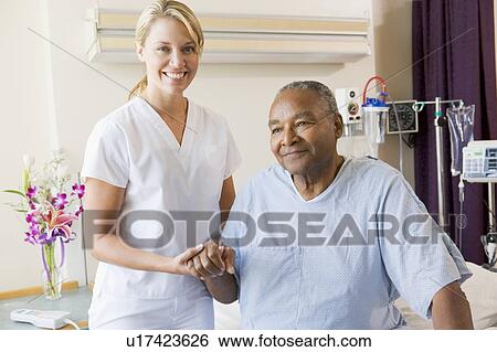 Stock Photograph - Nurse Helping Senior Man To Walk. Fotosearch