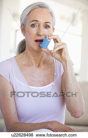 Stock Photo - Woman Using An Inhaler. Fotosearch