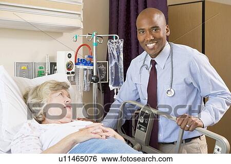 Doctor Checking Up On Patient Lying In Hospital Bed View Large Photo Image Stock Photograph - Doctor Checking Up On Patient Lying In Hospital Bed. Fotosearch