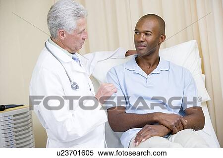 Stock Photography - Doctor giving man checkup in exam room. Fotosearch