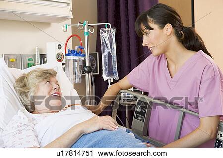 Stock Image - Nurse Talking To Senior Woman. Fotosearch