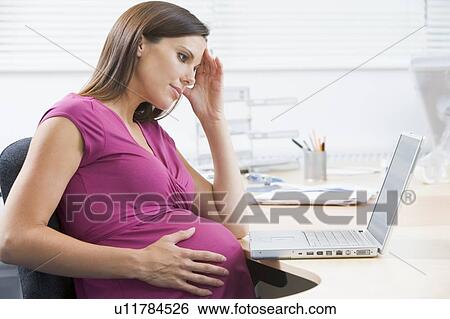 Pregnant woman at work with laptop looking stressed View Large Photo Image Stock Photograph - Pregnant woman at work with laptop looking stressed. Fotosearch
