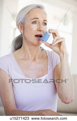 Stock Image - Woman Using An Inhaler. Fotosearch