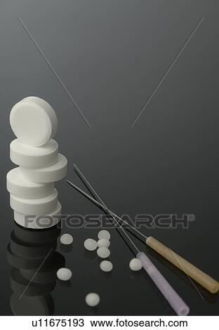 Stock Image - Dr. Schuessler cell salt pills and acupuncture needles. Fotosearch