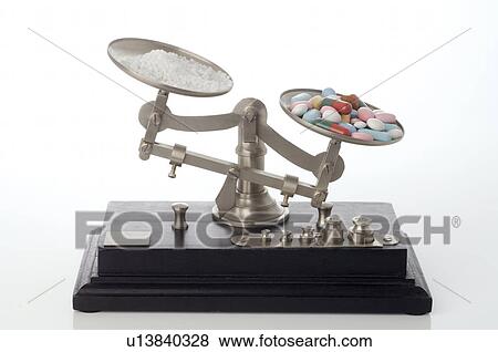 Stock Photo - Globules and pills on a scale. Fotosearch