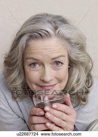 Picture - Senior citizen holding a glass. Fotosearch