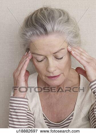 Senior woman massaging her temple View Large Photo Image Stock Photo - Senior woman massaging her temple. Fotosearch