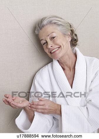 Senior woman with a pill in her hand View Large Photo Image Picture - Senior woman with a pill in her hand. Fotosearch