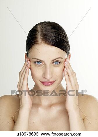 Stock Image - Woman is massaging her face. Fotosearch