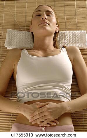 Woman lying on a mat View Large Photo Image Stock Image - Woman lying on a mat. Fotosearch