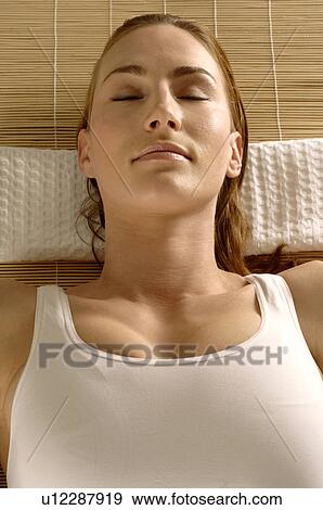 Woman lying on a mat View Large Photo Image Stock Photo - Woman lying on a mat. Fotosearch