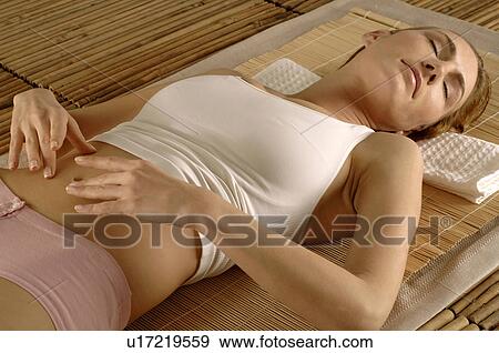 Stock Photo - Woman lying on a mat. Fotosearch