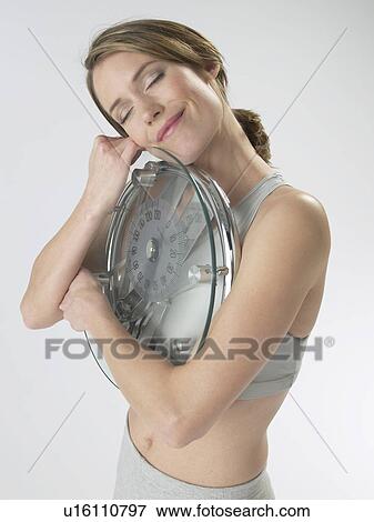 Woman with a bathroom scale View Large Photo Image Stock Photo - Woman with a bathroom scale. Fotosearch