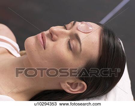 Stock Image - Young woman with rose quartz. Fotosearch