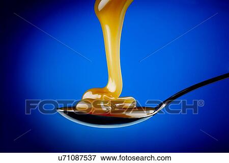 Caramel pouring onto a spoon View Large Illustration Stock Illustration - Caramel pouring onto a spoon. Fotosearch