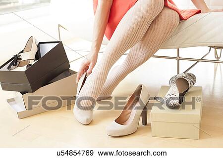 Stock Illustration - Woman trying on shoes. Fotosearch
