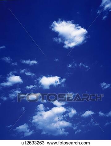 Stock Image - Blue sky and Clouds, Low angle view. Fotosearch