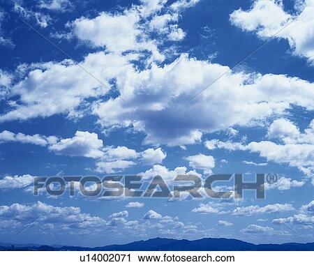 Stock Image - Blue sky and Clouds, Low angle view, Full frame. Fotosearch